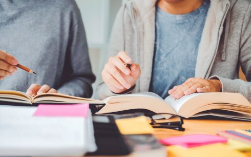 High school or college students studying and reading together in library