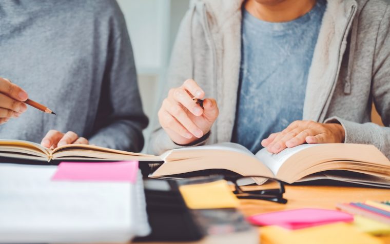High school or college students studying and reading together in library